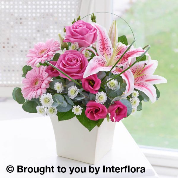 pink arrangement of flowers in a cream pot