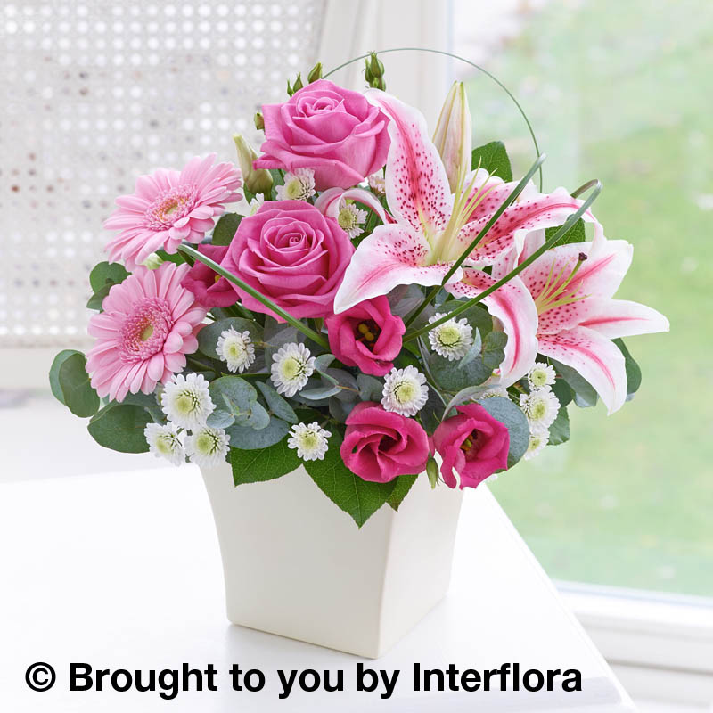 pink arrangement of flowers in a cream pot