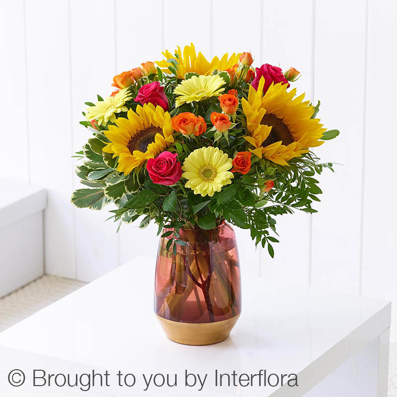 vase of flowers including sunflowers